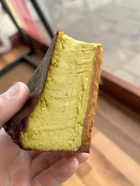 Slice of pistachio cheesecake on a chocolate base